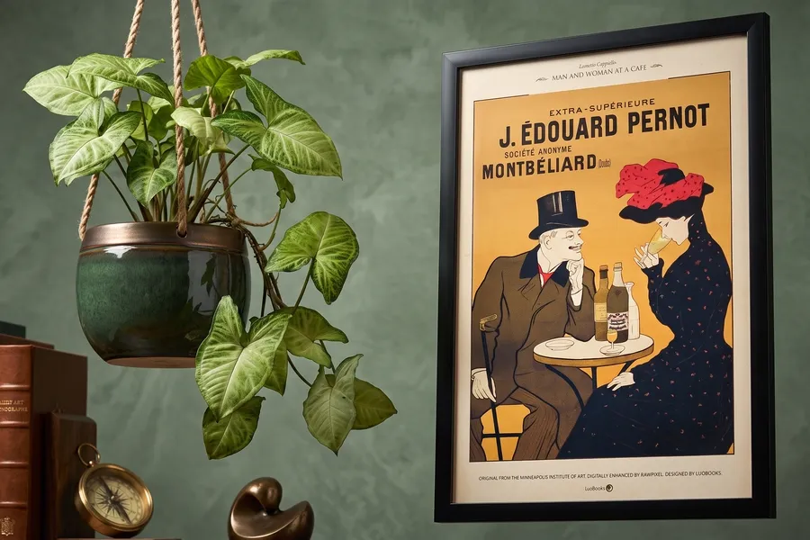 Pared verde del salón con una planta colgante y un afiche enmarcado